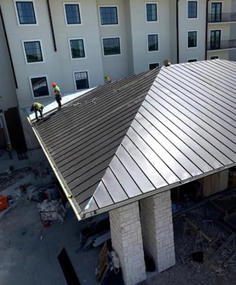 Crew installing standing seam metal roof panels on a commercial project in East Pasadena